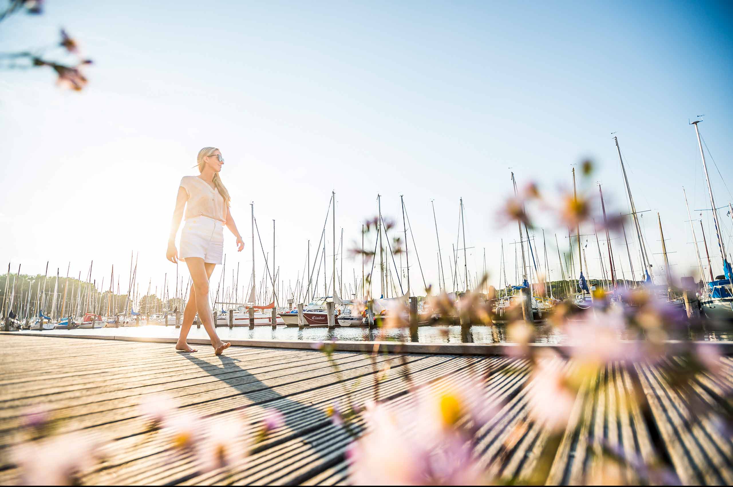Frau spaziert auf einem Steg im Fischereihafen 